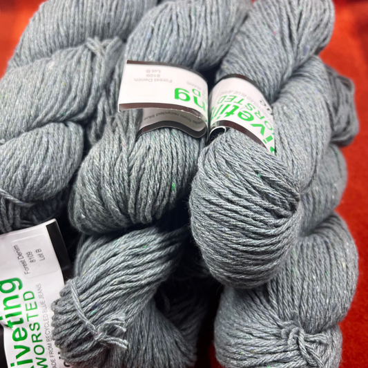 Six hanks of Kollage Yarns Riveting Worsted in Forest Denim, a blue-green yarn made from recycled denim. close up