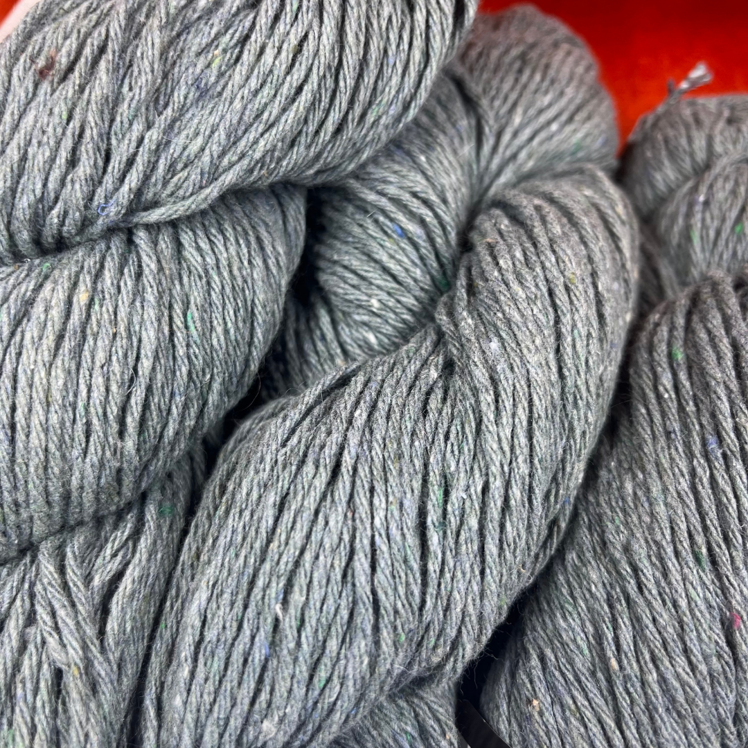Six hanks of Kollage Yarns Riveting Worsted in Forest Denim, a blue-green yarn made from recycled denim. super close up color