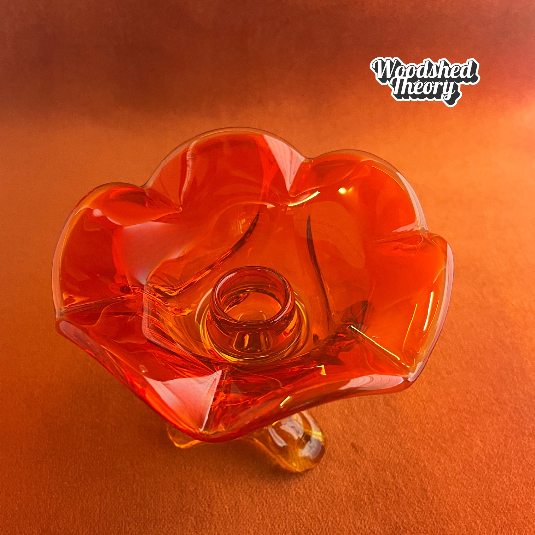 Viking Glass persimmon orange petal-shaped cadmium glass candle holder glowing under black light top down