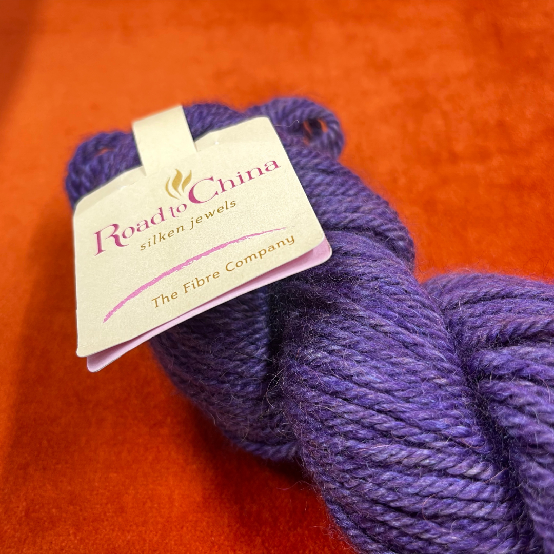Hank of Road to China by The Fiber Company in Rose de France – soft pink yarn made with baby alpaca, camel, cashmere, yak, and soya fiber, sport weight. close up label