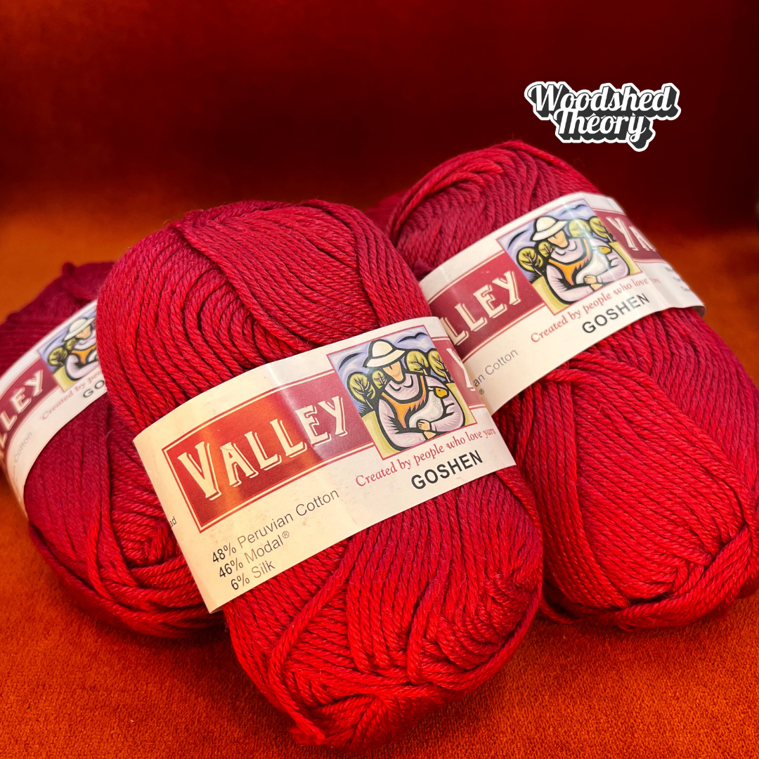 Five balls of Valley Yarns Goshen in vibrant red (color 06), cotton/modal/silk blend yarn, stacked neatly in a bundle. close up