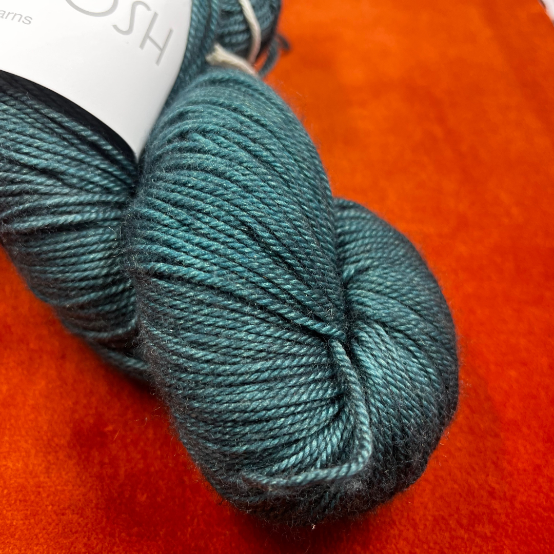 One skein of Madeline Tosh Pashmina yarn in Norway Spruce – a hand-dyed sport weight blend of merino, silk, and cashmere in deep green tones. close up color
