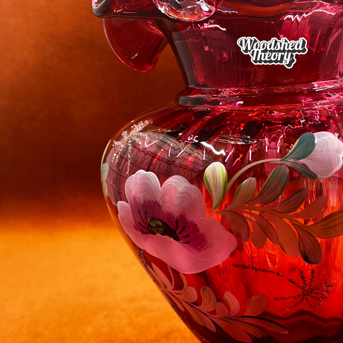 Fenton Art Glass cranberry basket with clear twisted handle, hand painted poppies, and gold glitter, signed by the artist. close up on painting, 95th anniversary
