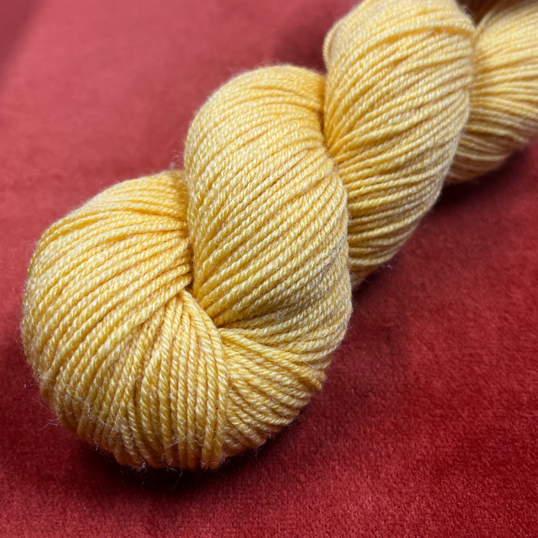 Hank of Spud and Chloe Fine sock yarn in sunny yellow color 7811, fingering weight wool and silk blend, 248 yards. close up bright light