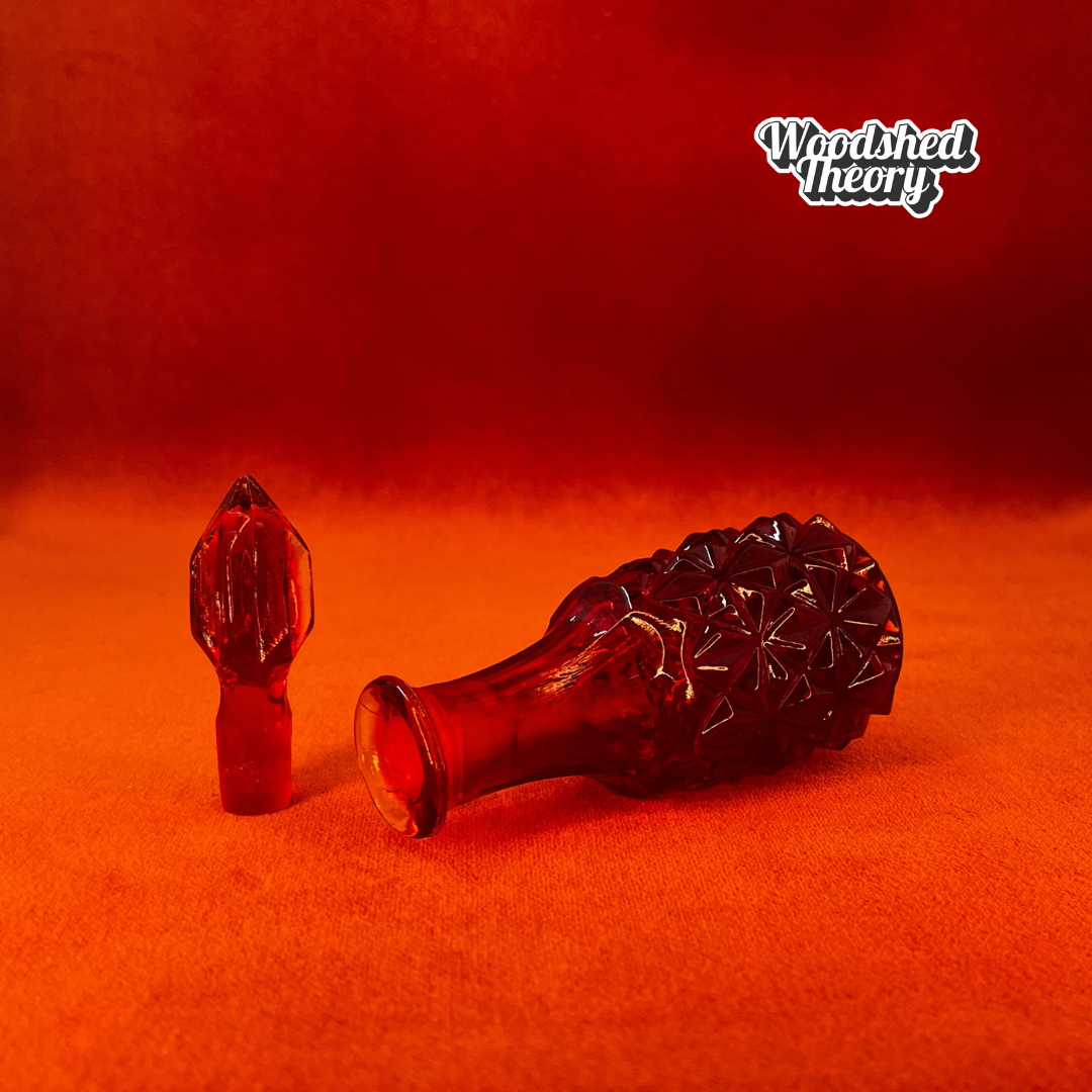 Amberina crystal vial with diamond facets and pointy stopper made in West Germany, glowing under black light cork off
