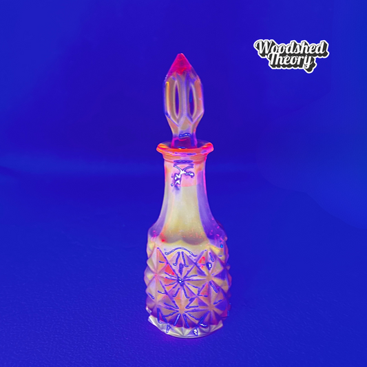 Amberina crystal vial with diamond facets and pointy stopper made in West Germany, glowing under black light