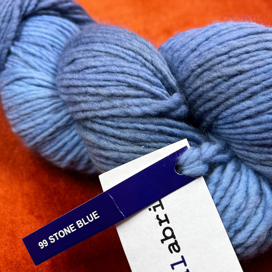 One hank of Malabrigo Worsted Roving in 99 Stone Blue, a soft gray-blue 100% merino wool yarn with subtle tonal variation. close up color