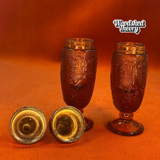 Pair of vintage amber pressed glass salt and pepper shakers with silver metal tops, green patina visible inside lids.Tiara Indiana Glass inside of lides