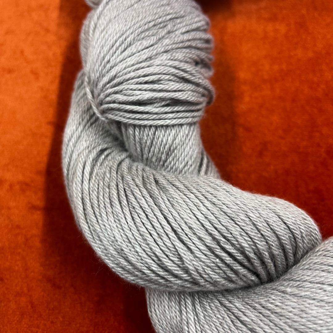 One hank of Berroco Pima 100 yarn in color Rye (8408), worsted weight matte beige cotton yarn. close up on color