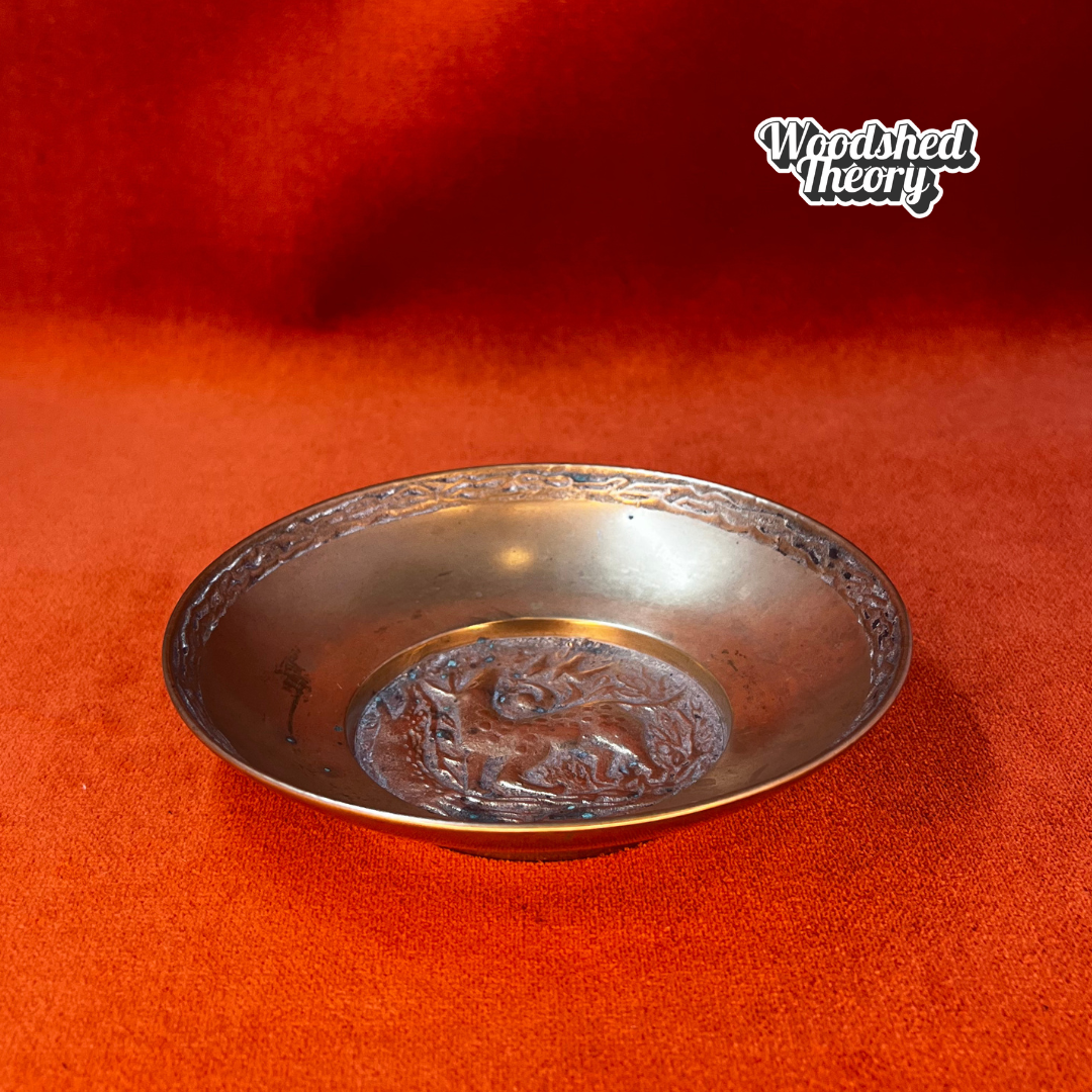 Solid bronze vintage ring dish showing a fawn walking in a wooded scene, stamped “Korea” on the bottom. side