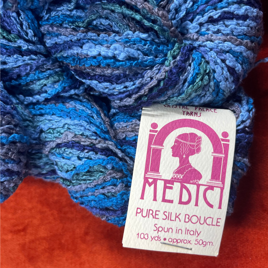 Crystal Palace Medici Pure Silk Boucle yarn in color 1492—bundle of 6 skeins in a mix of blues and greens, spun in Italy. close up on label