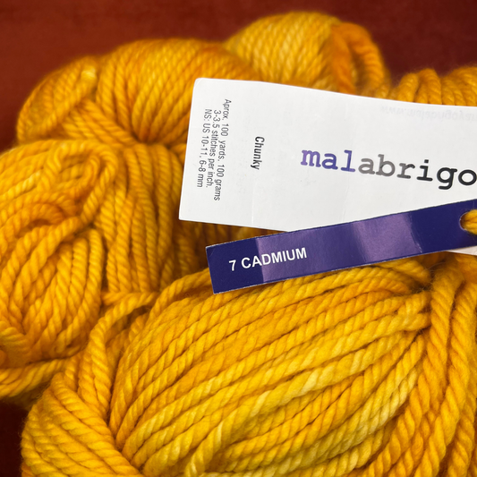 Two hanks of Malabrigo Chunky yarn in 7 Cadmium, a bright yellow 100% merino wool yarn, 200 yards total. close up