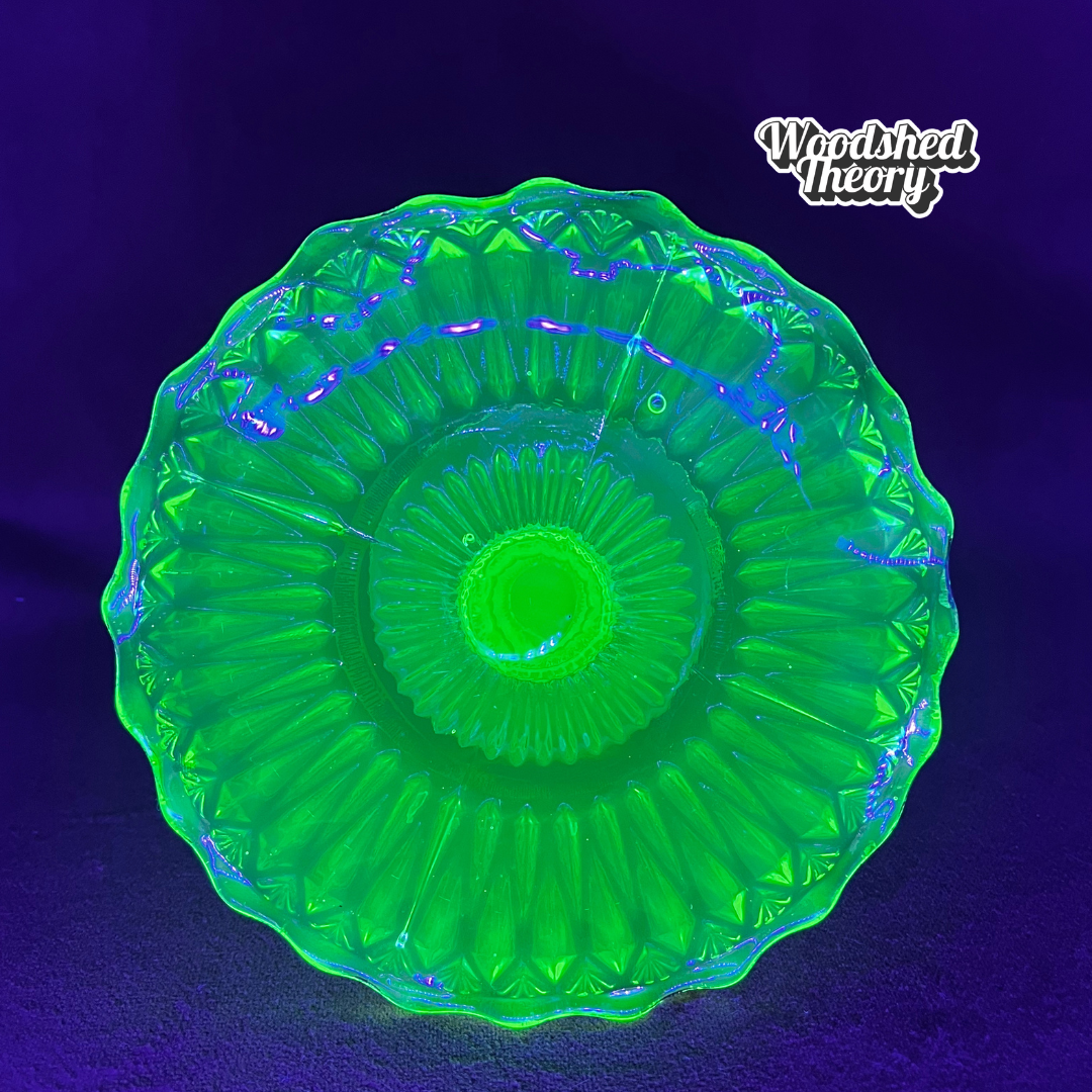 Vintage uranium glass candy or ring dish with ruffled edge and faded gold accents, collectible vaseline glass glowing green under black light. top glowing