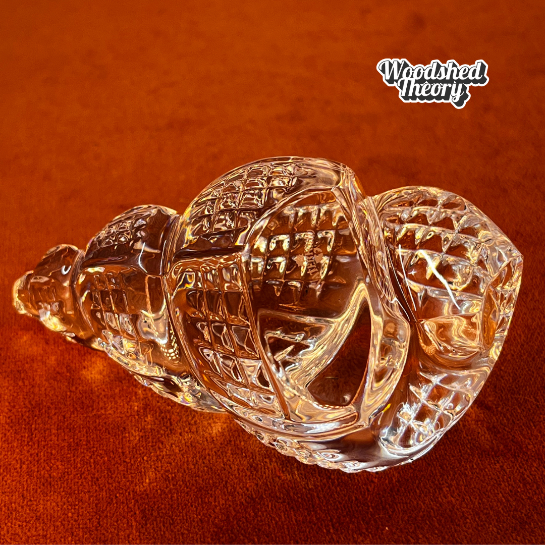 Clear Waterford Crystal conch shell paperweight with faceted design reflecting light; approx. 2.75” by 4.5”. close up