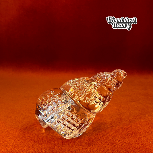 Clear Waterford Crystal conch shell paperweight with faceted design reflecting light; approx. 2.75” by 4.5”. side