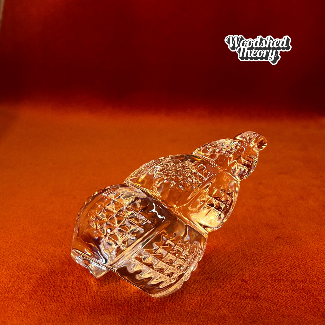 Clear Waterford Crystal conch shell paperweight with faceted design reflecting light; approx. 2.75” by 4.5”. side