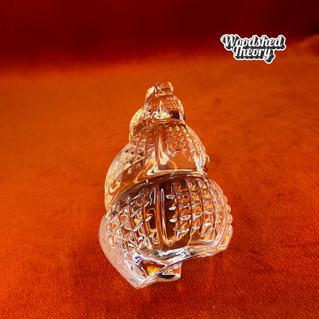 Clear Waterford Crystal conch shell paperweight with faceted design reflecting light; approx. 2.75” by 4.5”. front