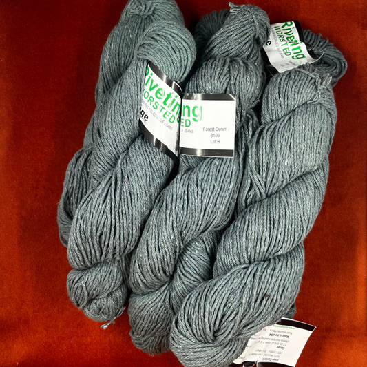 Six hanks of Kollage Yarns Riveting Worsted in Forest Denim, a blue-green yarn made from recycled denim. top down