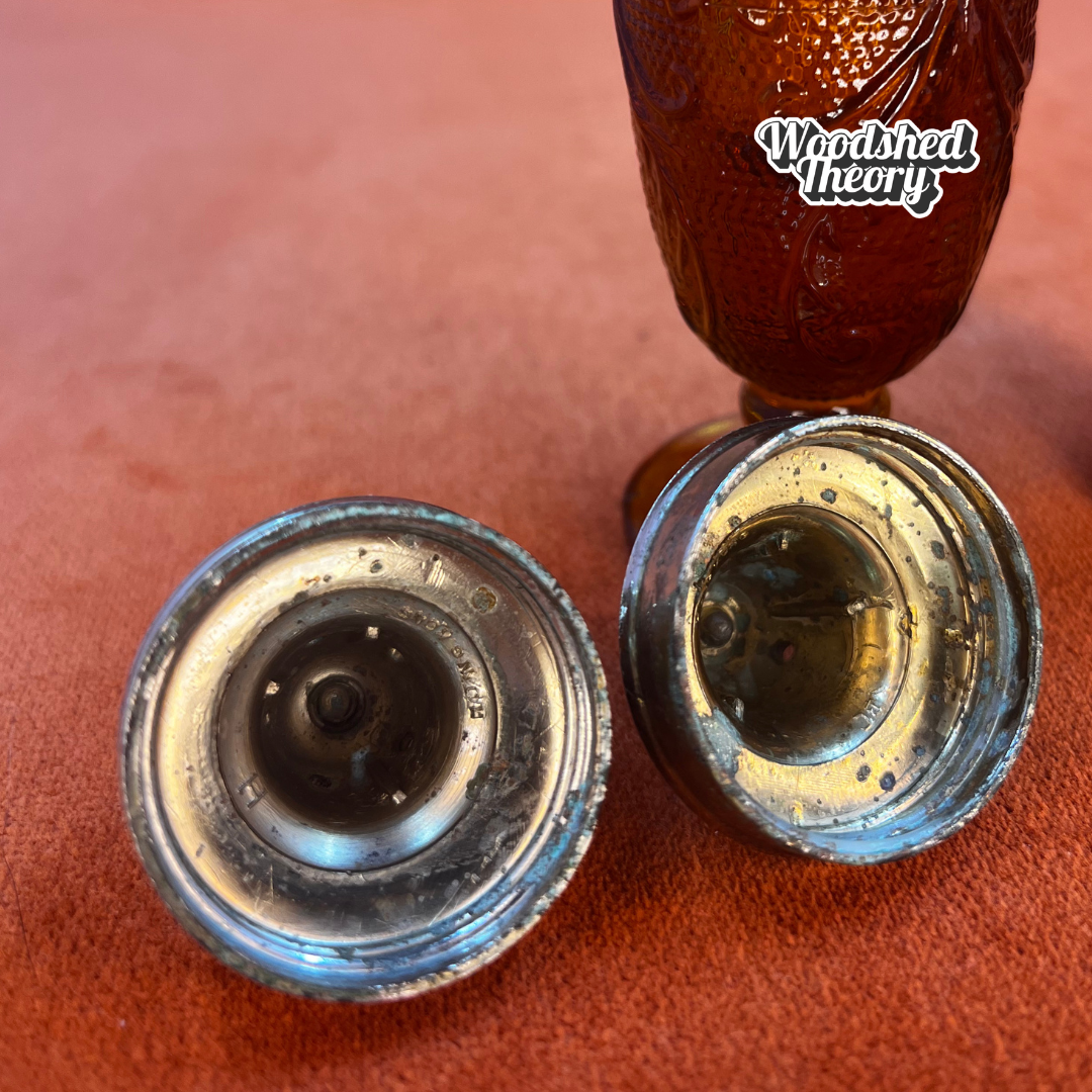 Pair of vintage amber pressed glass salt and pepper shakers with silver metal tops, green patina visible inside lids.Tiara Indiana Glass close up of the inside of lids 