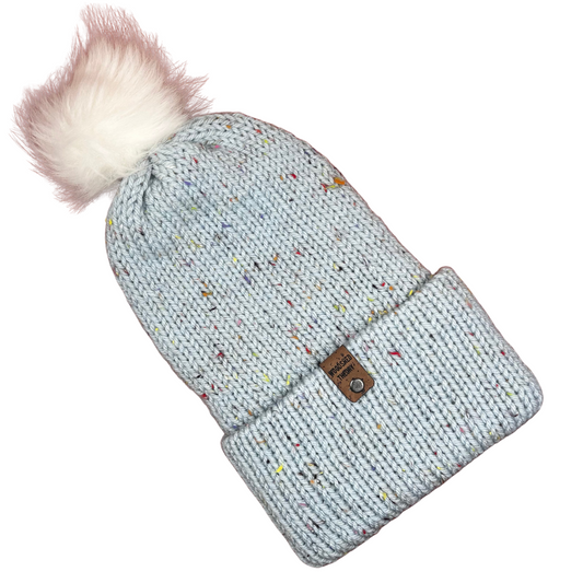 Knitted blue beanie with colorful speckles and a fluffy pom-pom on a white background the basic beanie in robins egg front flat
