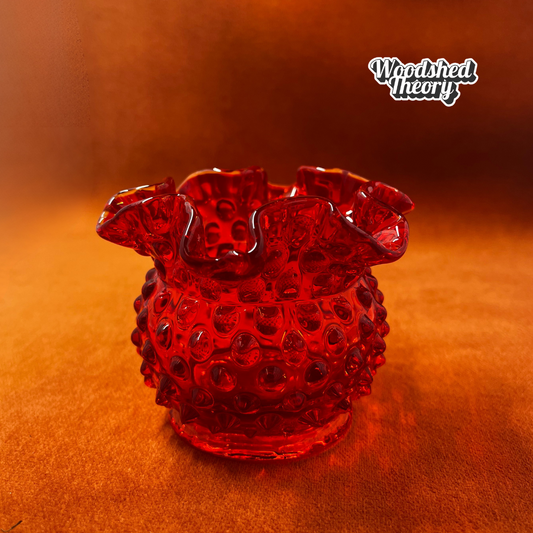 Fenton Amberina hobnail textured red-orange glass candle holder glowing orange under black light front