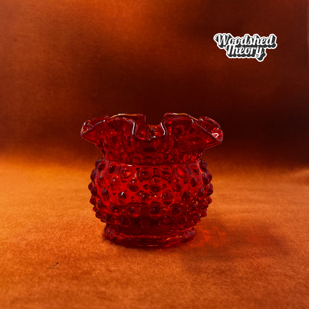 Fenton Amberina hobnail textured red-orange glass candle holder glowing orange under black light side profile