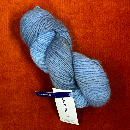 One hank of Malabrigo Worsted Roving in 99 Stone Blue, a soft gray-blue 100% merino wool yarn with subtle tonal variation. top down