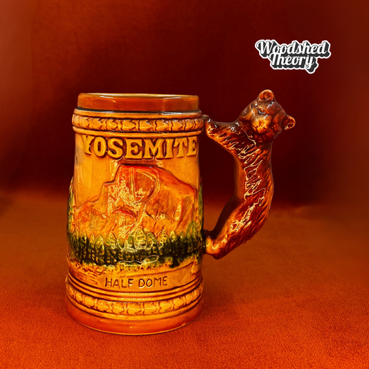 Vintage 1950s ceramic Yosemite souvenir mug with California bear handle and raised reliefs of Half Dome and El Capitan. front