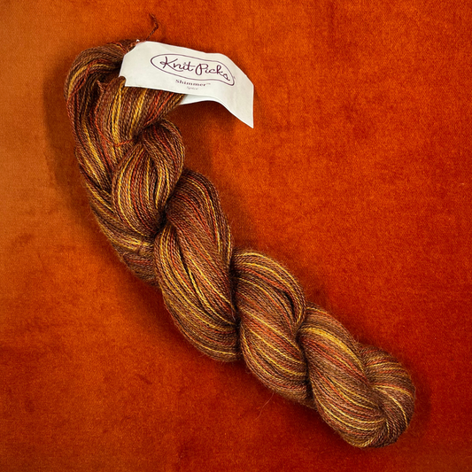 One hank of Knit Picks Shimmer lace weight yarn in a warm Spice color, made of baby alpaca and silk. top down 