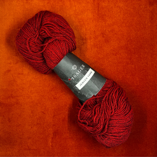 A single hank of Isager Jensen yarn in deep red (32s), 100% wool, neatly twisted and ready for knitting. top down