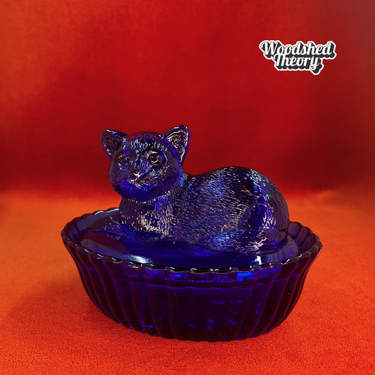 Vintage Westmoreland cobalt blue glass cat on nest dish with lid, shown from side angle. front