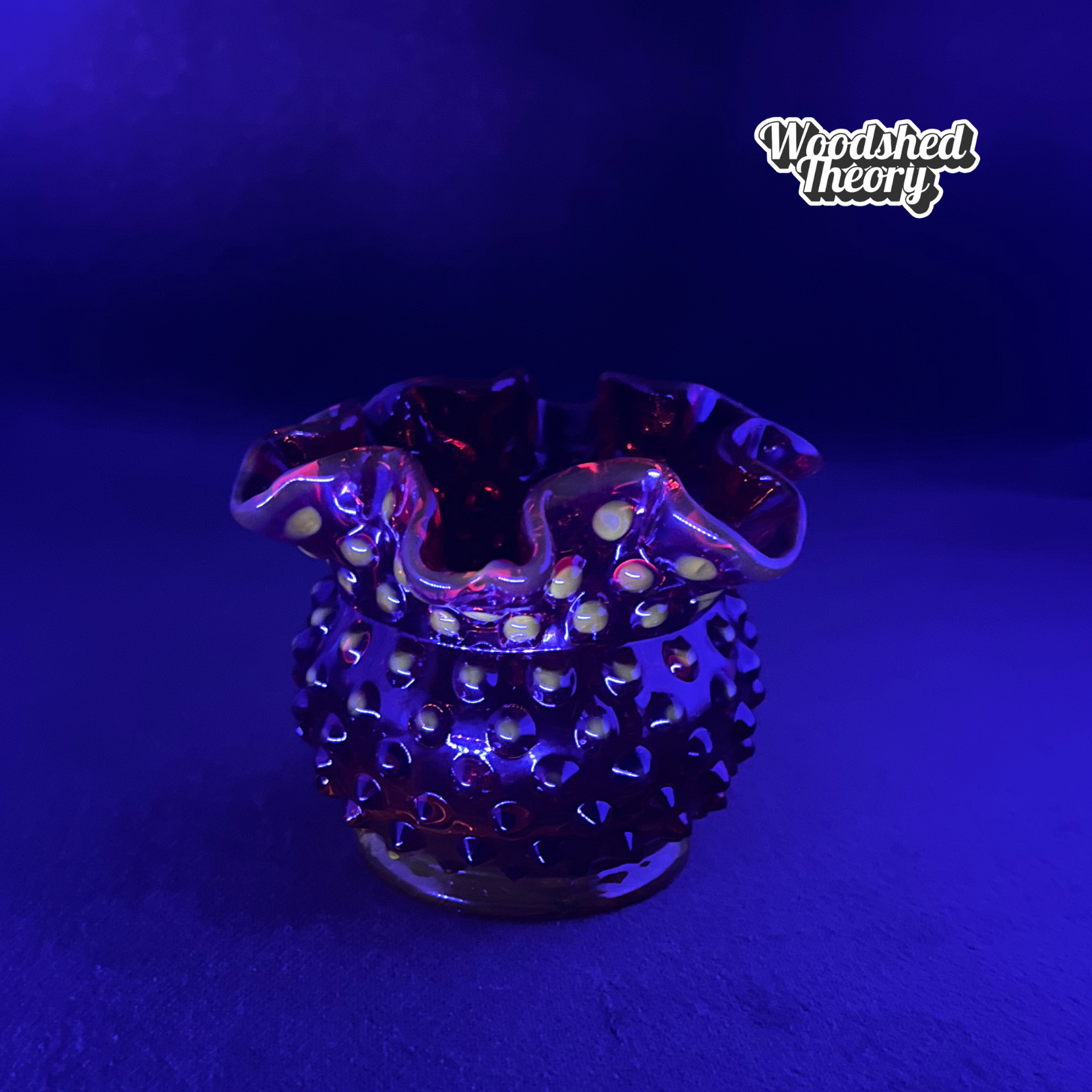 Fenton Amberina hobnail textured red-orange glass candle holder glowing orange under black light black light sample