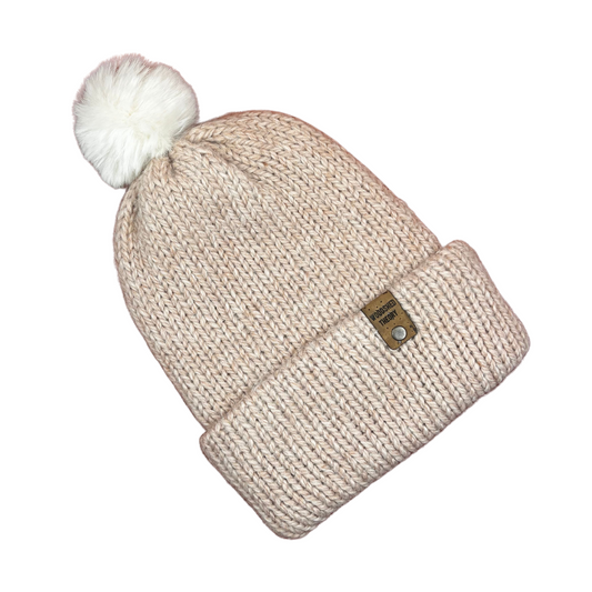 Beige knit beanie with a white pom-pom on a white background alpaca snow nude pink front