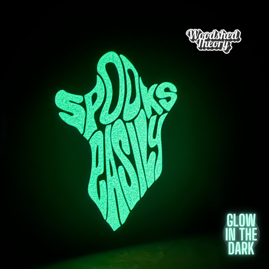 A glow-in-the-dark ghost-shaped iron-on patch that reads "Spooks Easily" in playful block lettering. The patch is handmade and approx. 5 by 5.5 inches. Front Glowing  Glow in the dark 