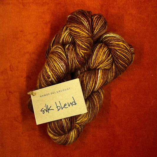Two hanks of MANOS del URUGUAY Silk Blend yarn in the color Prairie, a hand-dyed blend of tussah silk and merino wool. top down roving
