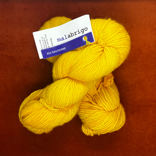 Two hanks of Malabrigo Worsted Roving in 022 Sauterne, a golden yellow 100% merino wool yarn, soft single-ply texture. top down 