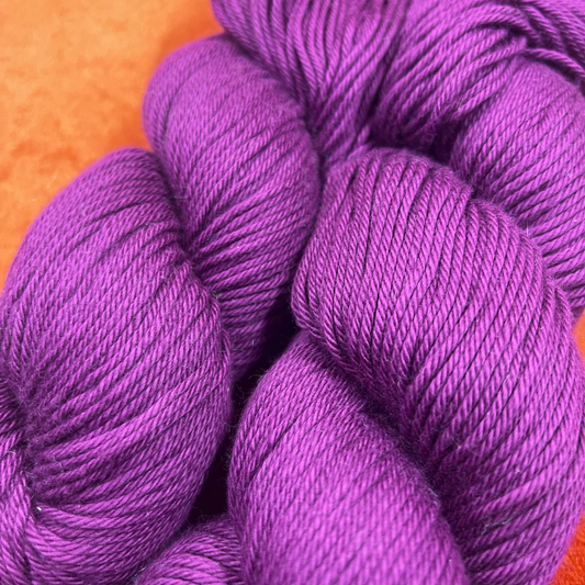 Two skeins of Berroco Pima 100 yarn in color Fox Glove (8444), soft matte pink worsted weight cotton yarn. close up