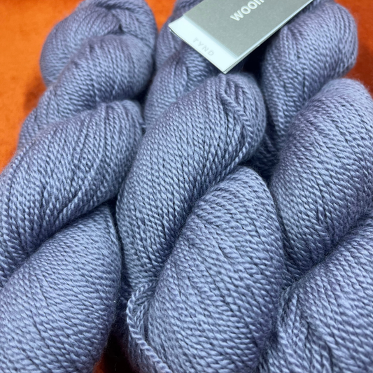 Three skeins of Woolfolk TYND yarn in Color 41 (periwinkle grey), fingering weight 100% Ovis 21 Merino wool. close up