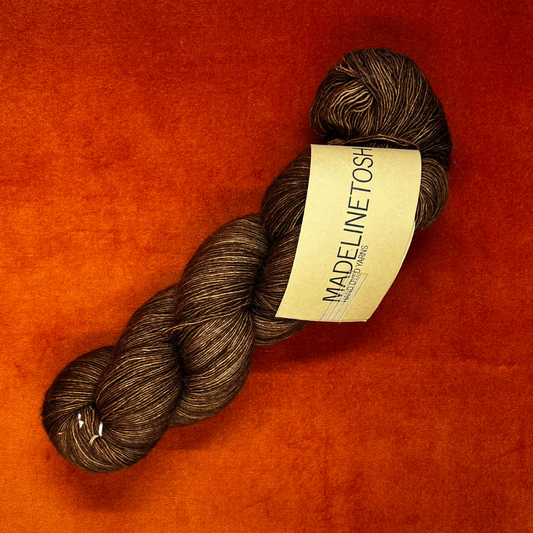 One skein of Madelinetosh Prairie yarn in Log Cabin Brown – a lace weight, single-ply superwash Merino yarn in rich earthy brown tones. top down