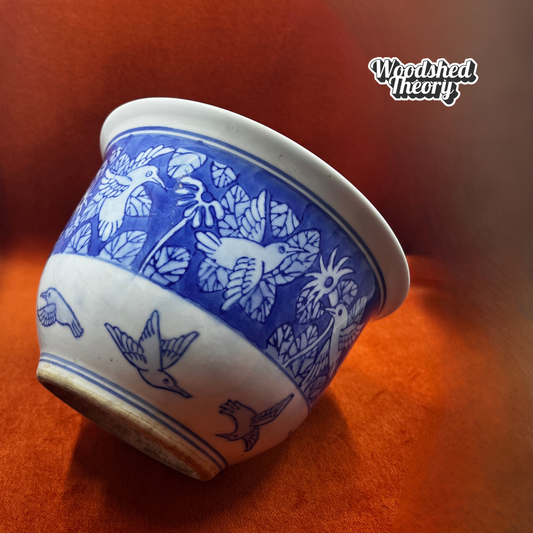 Blue and white hand-painted ceramic planter featuring Chinoiserie-style hummingbirds and foliage. Tilted Side