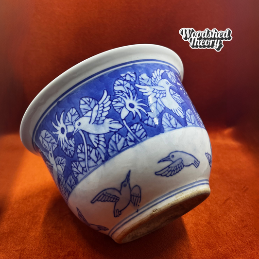 Blue and white hand-painted ceramic planter featuring Chinoiserie-style hummingbirds and foliage. tilted left side 