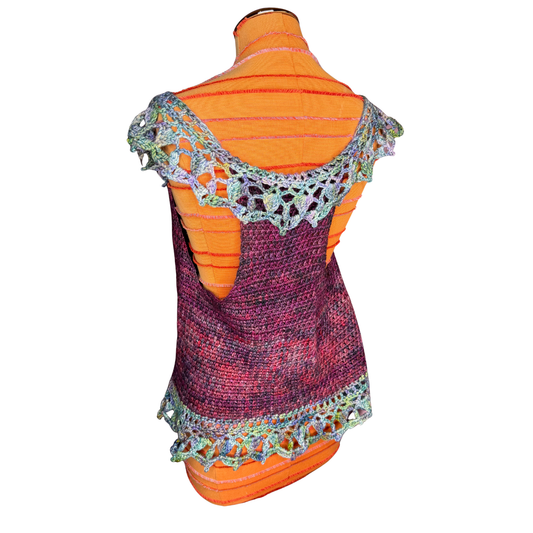 A colorful knit shrug or wrap with a multicolor variegated body and a light blue-green crochet lace trim, displayed on an orange striped mannequin torso against a white background.