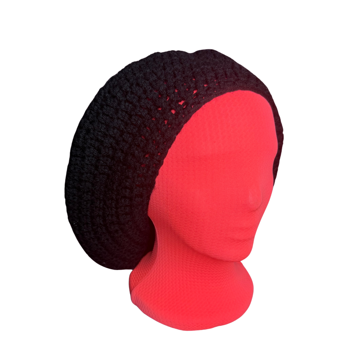 A black crocheted slouchy beanie hat displayed on a bright red mannequin head against a plain white background.