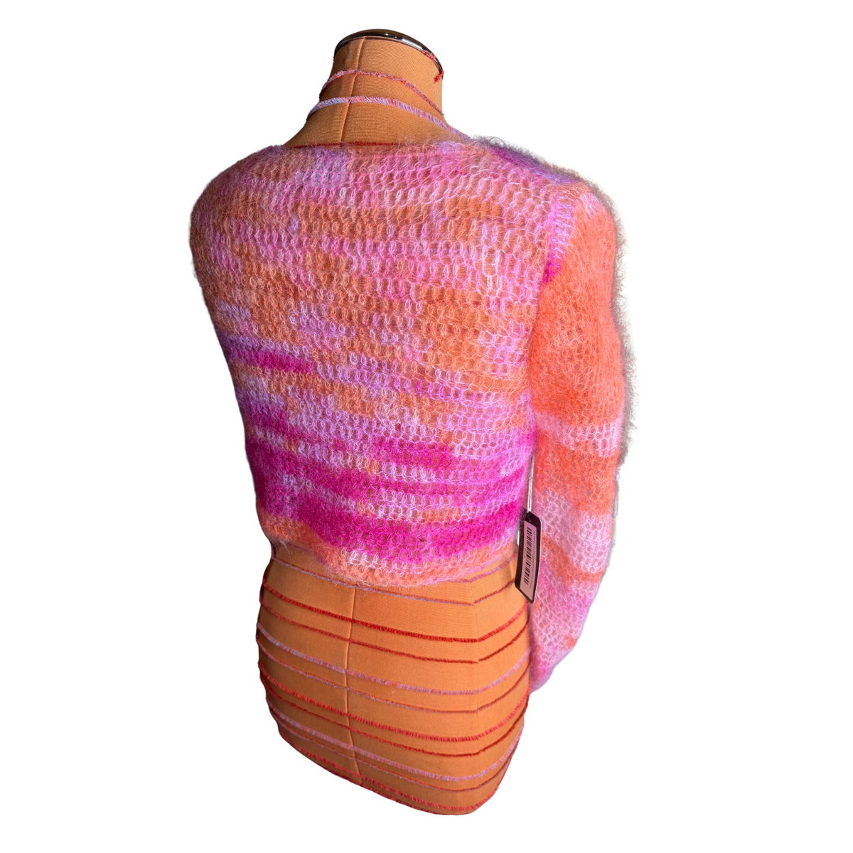A fuzzy knit cardigan sweater in a variegated pink, orange, and purple colorway, displayed on an orange mannequin torso against a white background.