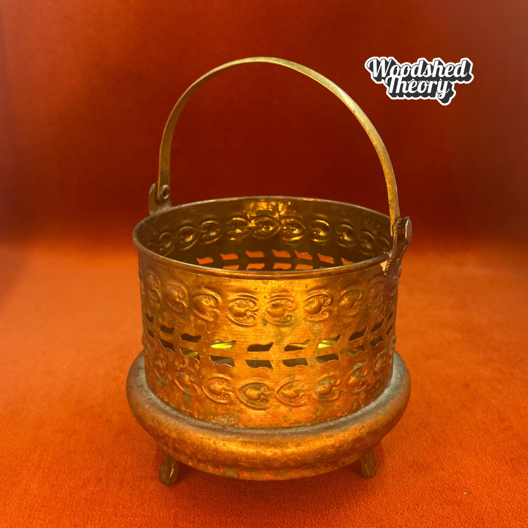 Small vintage Moroccan-style brass basket with posable handle and aged patina; perfect for candles or incense.
front