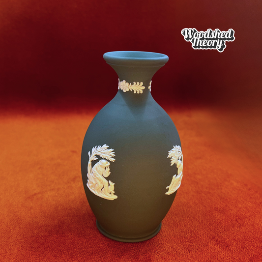 Jade green Wedgwood jasperware bud vase with white cherub and classical figure relief. Man with dog under tree