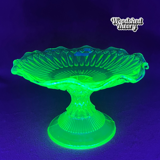 Vintage uranium glass candy or ring dish with ruffled edge and faded gold accents, collectible vaseline glass glowing green under black light. front glow