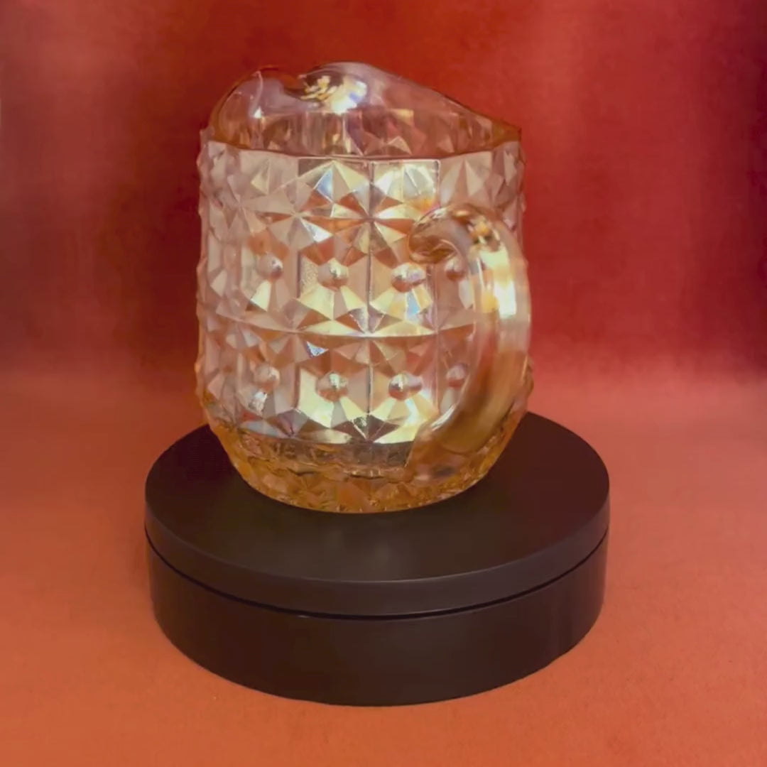 Vintage Jeannette Glass Company Buttons and Bows milk pitcher in iridescent amber, 1947–1949, with handle and shimmering finish. video spin