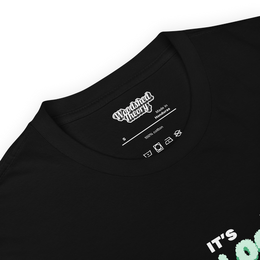 Black unisex t-shirt with white text that reads 'It’s Neurological' — neurodivergent pride shirt by Woodshed Theory inside printed label of shirt 