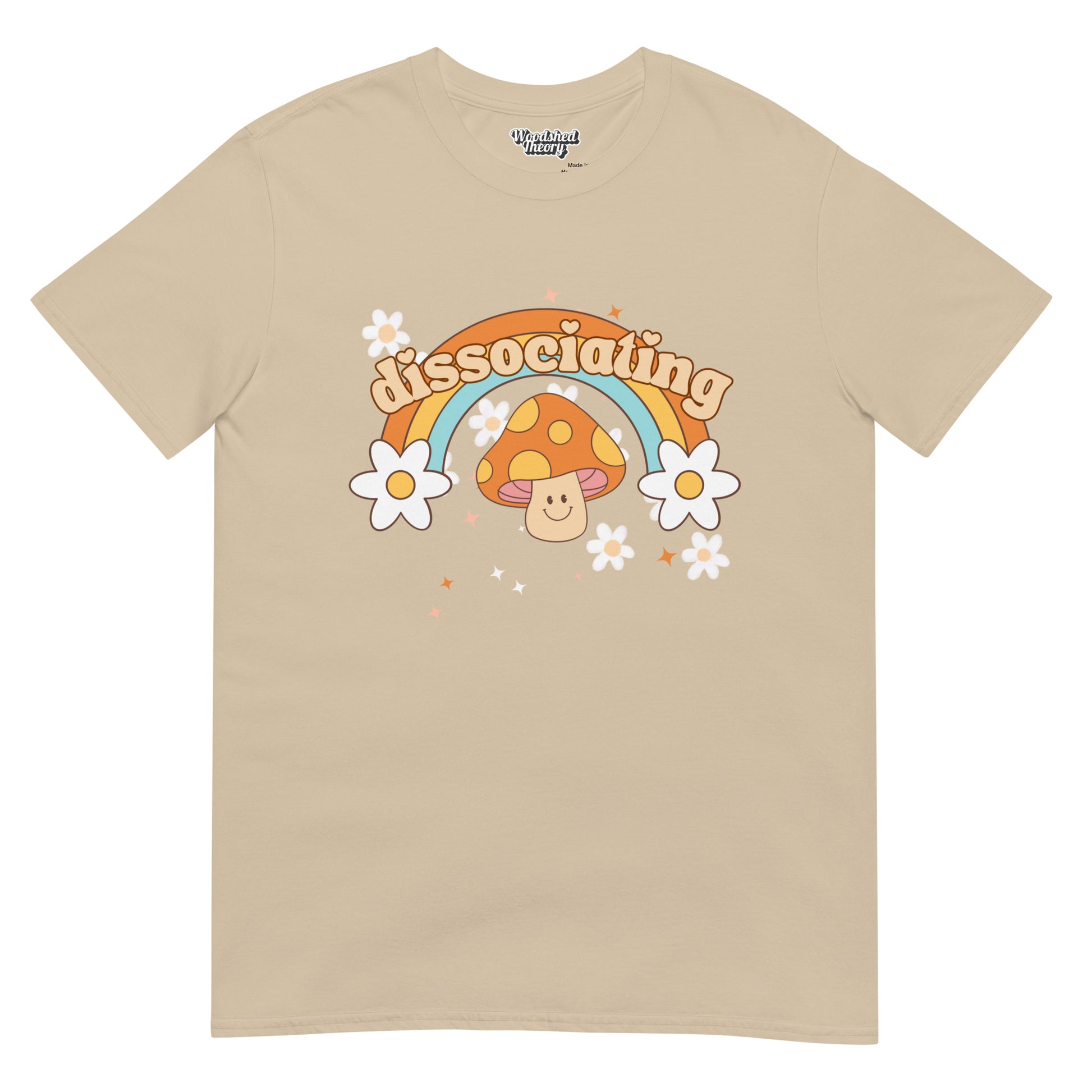 Retro-style t-shirt with rainbow, sparkles, and grinning mushroom with 'Dissociating' text — neurodivergent-friendly graphic tee from Woodshed Theory color sand front flat 